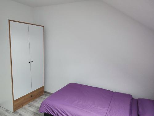 1 dormitorio con cama morada y espejo en Bella apartman, en Brčko