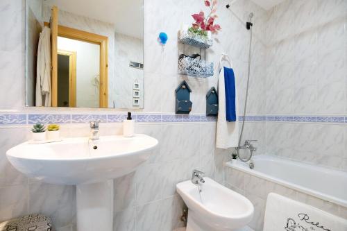 een badkamer met een wastafel, een toilet en een bad bij Apartaclub la Barrosa in Chiclana de la Frontera