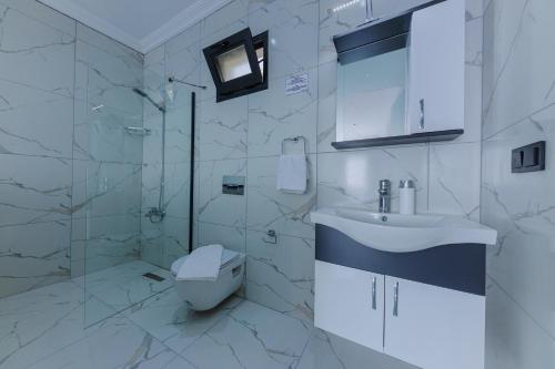 uma casa de banho branca com um lavatório e um WC em Villa Arya em Kas