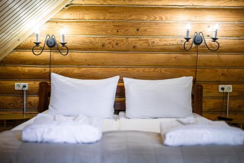 a bed with two pillows and two lights on it at Bogolvar Retreat Resort in Antonovka