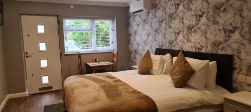 a bedroom with a large bed with white pillows at The Golf Studio Woodhall Spa in Woodhall Spa
