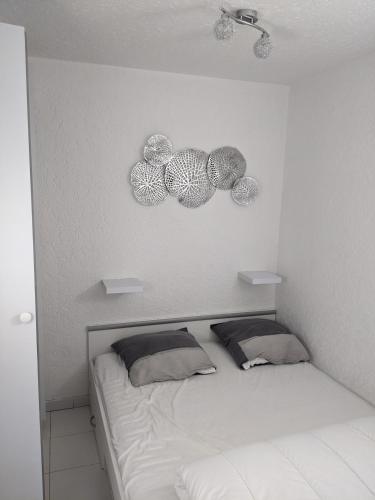 - une chambre dotée d'un lit avec trois plaques murales dans l'établissement appartement Cap d'Agde, au Cap d'Agde