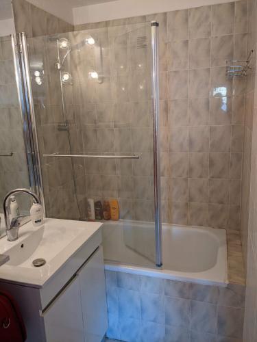 une salle de bain avec une douche, une baignoire et un lavabo dans l'établissement appartement Cap d'Agde, au Cap d'Agde