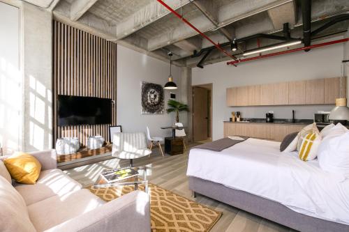 a bedroom with a large bed and a couch at Factory Lofts Hotel in Medellín