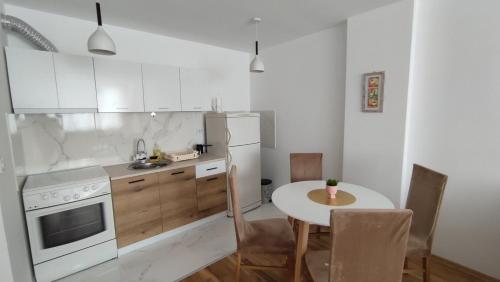 a kitchen with a table and a white refrigerator at Sunny Guest House in Skopje