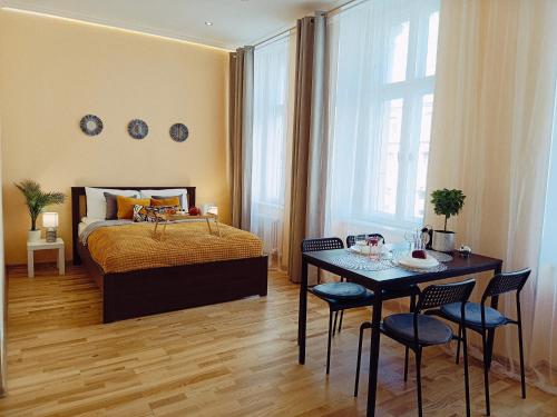 a bedroom with a bed and a table with chairs at Centrally located Studio apartment in Riga
