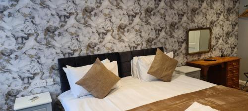 a bed with white sheets and pillows in a bedroom at The Golf Studio Woodhall Spa in Woodhall Spa