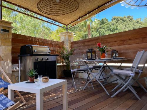 d'une terrasse avec un grill, une table et des chaises. dans l'établissement Appartement de charme, à Six-Fours-les-Plages