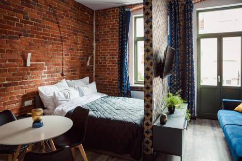 Pokój z łóżkiem i ceglaną ścianą w obiekcie East Street Apartamenty w Łodzi