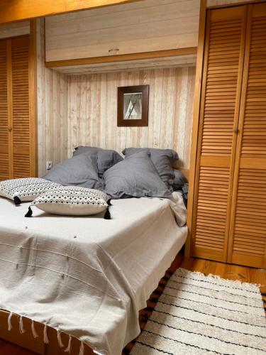 une chambre avec un grand lit avec un mur en bois dans l'établissement Appartement de charme, à Six-Fours-les-Plages