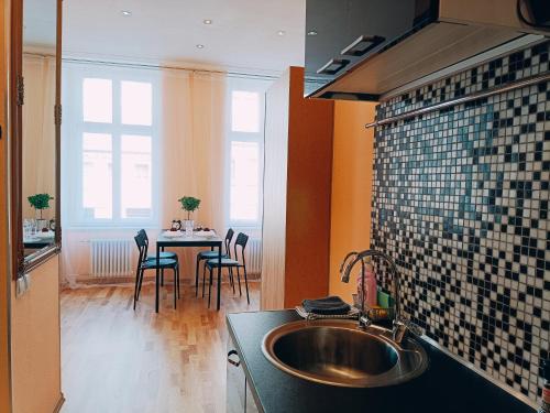 a kitchen with a sink and a table with chairs at Centrally located Studio apartment in Riga