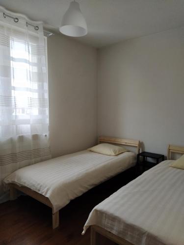 RancyにあるMaison 3 chambres 6 lits Netflix Parkingの窓のある小さな部屋にベッドが2つある