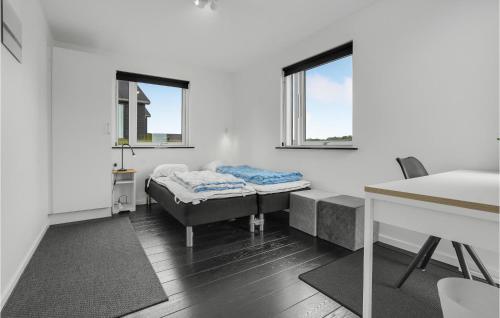 a room with a bed and a table and two windows at Holiday Home Kelstrup Klint Haderslev Iii in Kelstrup