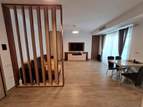 a living room with a sliding door with a table and a television at Matteo 2 Apartments Marina Surf Residence, Mamaia Nord - Năvodari,1 vedere frontala,2 cu vedere laterala la mare in Năvodari