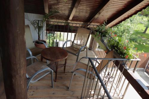 a wooden porch with chairs and a table on a balcony at MaRéJa Vendégház in Hortobágy
