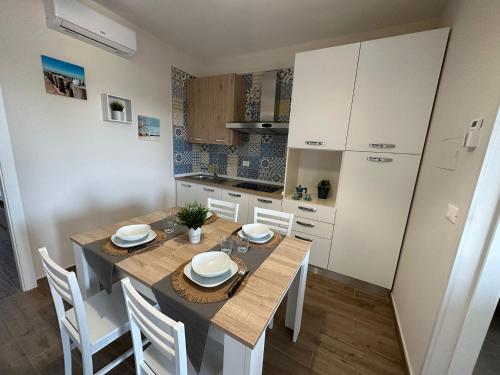 a kitchen and dining room with a table and chairs at BlueSun Apartments in Leporano Marina