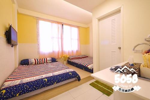 a bedroom with two beds and a television in it at 逢甲晨熙 in Taichung