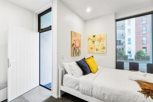 een slaapkamer met een bed en een raam bij Gorgeous Studio - Heart of Avondale - Netflix WiFi in Auckland