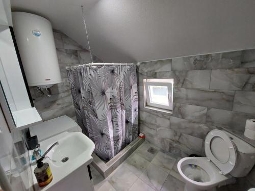 a bathroom with a sink toilet and a shower curtain at Vožd in Kladovo