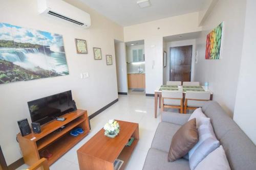 a living room with a couch and a tv at Mactan Newtown Beach Condo in Mactan