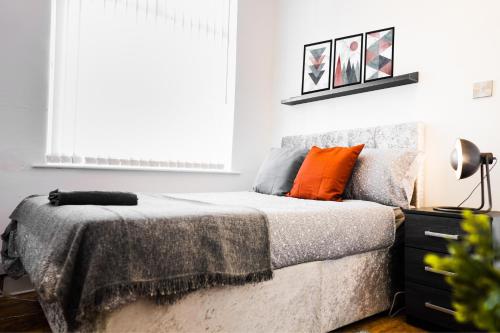 1 dormitorio con 1 cama con almohada naranja en Daze Private 1-Bedroom Near to City Centre en Liverpool