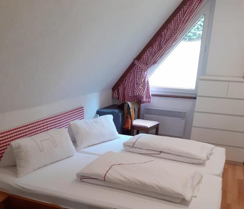 a bedroom with a bed with white sheets and a window at Appartement Hardenack in Innerkrems