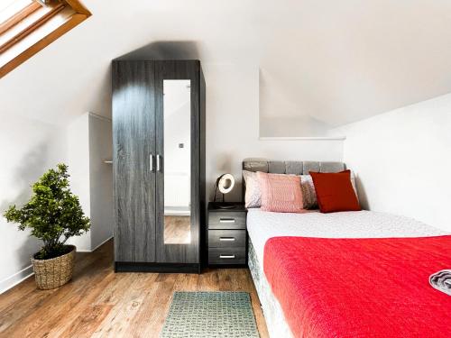 a bedroom with a red bed and a mirror at Laid-back Midtown Retreat in Liverpool