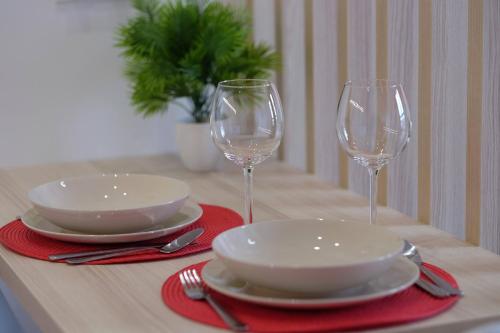 two empty wine glasses and plates on a table at Apartamenty Centrum in Białystok