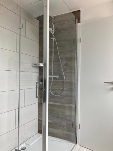La salle de bains est pourvue d'une douche avec une porte en verre. dans l'établissement Helle Fewo Haus 29a, 2. Obergeschoss, à Deensen