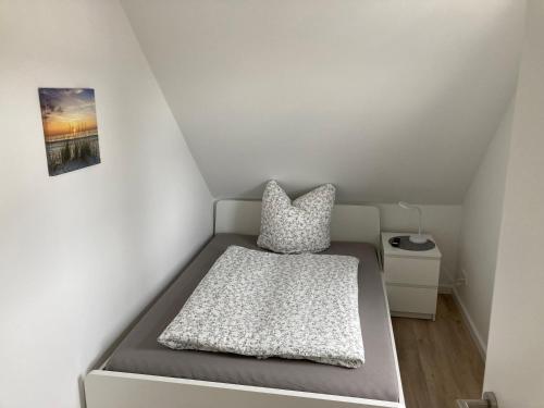 ein kleines Schlafzimmer mit einem Bett und einem Kissen in der Unterkunft Helle Fewo Haus 29a, 2. Obergeschoss in Deensen