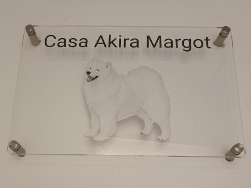 a white cat is standing under a sign at Casa Akira Margot in Floridia