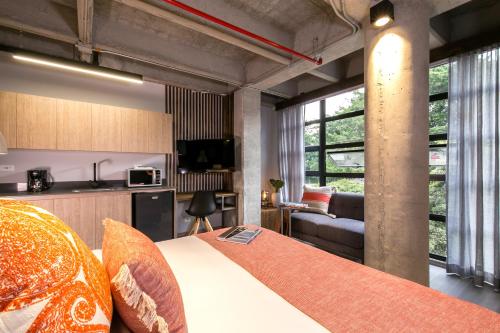 a room with a bed and a kitchen with a couch at Factory Lofts Hotel in Medellín