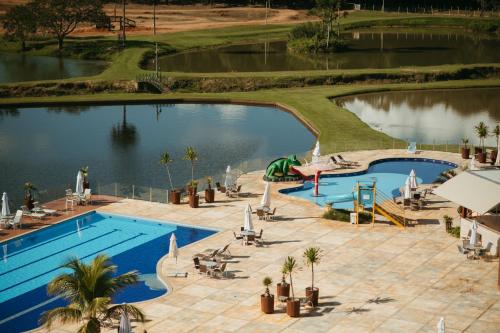 an overhead view of a swimming pool with a lake at Engenho da Serra Hotel EcoResort in Capitólio