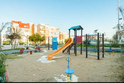 einen Spielplatz mit Rutsche in einem Park in der Unterkunft Appartement tanger Beach in Tangier