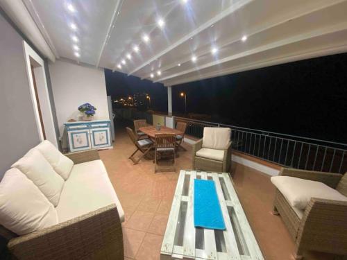 a balcony with a couch and a table and chairs at Sunrise Apartment in Castelsardo