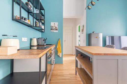 a kitchen with blue walls and a counter top at Cozy 2-Raumwohnung in Zentrumsnähe in Leipzig