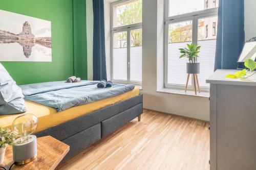 a bedroom with a bed and two windows at Cozy 2-Raumwohnung in Zentrumsnähe in Leipzig