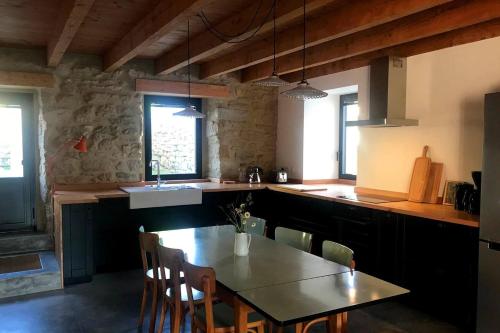 une cuisine avec une table, des chaises et un évier dans l'établissement Saint-Tuge Maison de vacances, à Esquibien