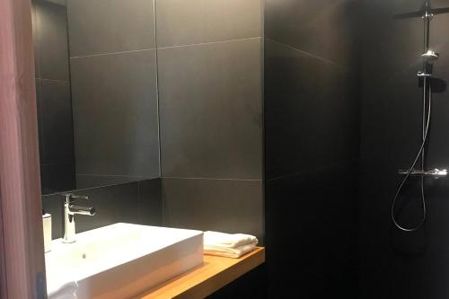 une salle de bain avec un lavabo et un miroir dans l'établissement Saint-Tuge Maison de vacances, à Esquibien