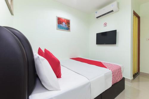1 cama blanca con almohadas rojas en una habitación en OYO 444 KL Empire Hotel, en Subang Jaya