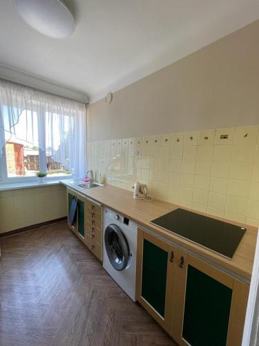 uma cozinha com um lavatório e uma máquina de lavar roupa em Dzīvoklis Raiņa ielā 57 em Liepāja