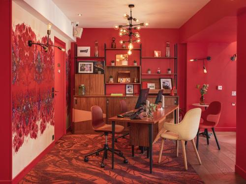 an office with red walls and a desk with a computer at Hôtel Exquis in Paris