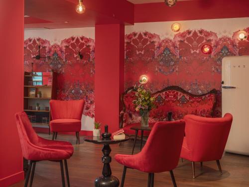 a room with red chairs and a red wall at Hôtel Exquis in Paris
