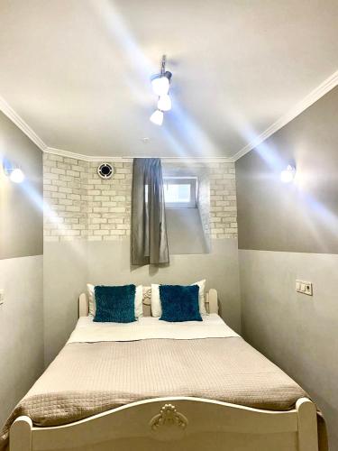 a bedroom with a large bed with blue pillows at Budget Family Hotel in Lviv