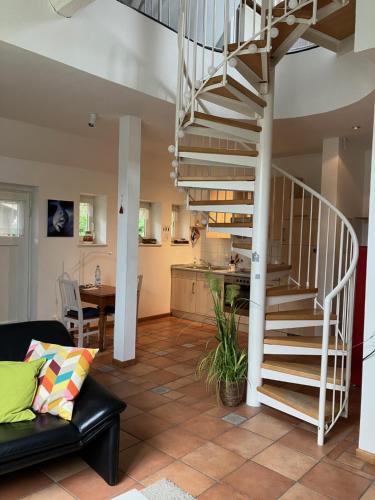 a living room with a spiral staircase and a kitchen at Ferienapartment Kastanje in Groß Ippener