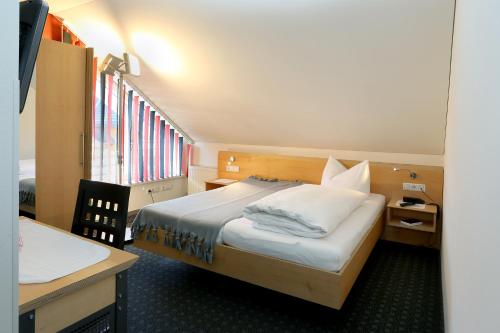 a hotel room with a bed and a desk and a bed sidx sidx at Schäfle Feldkirch-Altenstadt in Feldkirch