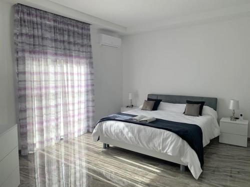 a bedroom with a large bed and a large window at Spacious lovely apartment in Mġarr 1 in Mġarr