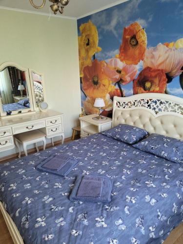 Ulbrokas Apartment في ريغا: غرفة نوم مع سرير مع زهور مرسومة على الحائط