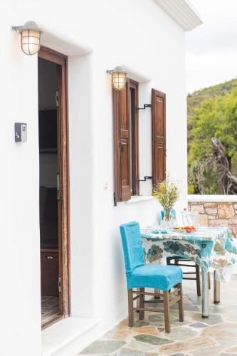 a table and chairs on a patio with a window at Maria's Traditional Villa in Asklipiḯon