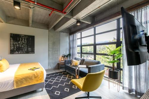 a bedroom with a bed and a tv in a room at Factory Lofts Hotel in Medellín